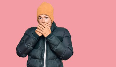 Kar giyen yakışıklı beyaz adam yanlışlıkla elleri ile ağzını kapatan şok olmuş bir giysi giyiyor. gizli kavram. 