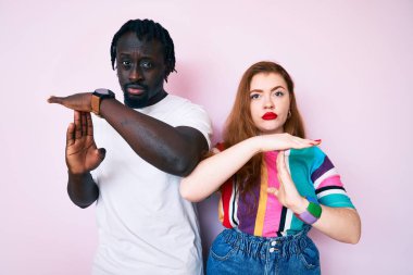 Irklar arası giyinen, gündelik kıyafetler giyen, el kol hareketleri yapan, hayal kırıklığına uğramış ve ciddi yüzlü bir çift. 