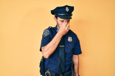 Orta yaşlı İspanyol polis üniforması giyen, burnu ve gözleri ovuşturmaktan yorgun düşmüş yorgun ve başı ağrıyor. Stres ve hüsran kavramı. 