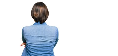 Kısa saçlı, sıradan bir kot ceket giyen genç, güzel bir İspanyol kadın arkasını dönüp kollarını kavuşturmuş bakıyor. 