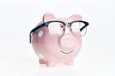 İzole edilmiş beyaz arka planda gözlüklü komik domuzcuk kumbarası.