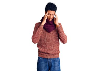 Genç Afro-Amerikan bir adam günlük kışlık süveter ve kafasında eşarp giyiyor. Stres yüzünden baş ağrısı çekiyor. migren ağrısı. 