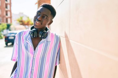 Şehrin caddesinde kulaklık kullanan Afrikalı genç bir Amerikalı..