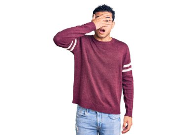 İspanyol asıllı yakışıklı genç adam gündelik giysiler giymiş. Şoka girmiş, yüzünü ve gözlerini kapamış, utanmış bir ifadeyle parmaklarından bakıyor.. 