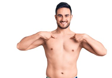 Mayo giyen, kendine güvenen, gülümseyen, kendini gururlu ve mutlu gösteren genç bir adam.. 