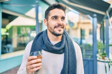 Genç İspanyol gülümseyen mutlu bir adam şehirde kahve içiyor..