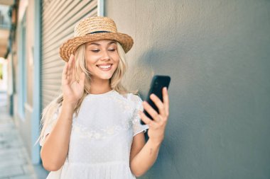 Kafkasyalı genç turist kız şehirde akıllı telefon kullanarak video görüşmesi yapıyor..