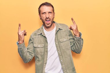 Genç, yakışıklı, günlük kıyafetler giymiş, çılgın bir ifadeyle bağıran, elleri havada rock sembolü yapan bir adam. Müzik yıldızı. ağır kavram. 