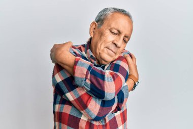 Üst düzey İspanyol adam günlük kıyafetler giyip kendine sarılıyor mutlu ve pozitif, kendinden emin gülümsüyor. Sevgi ve özgüven. 