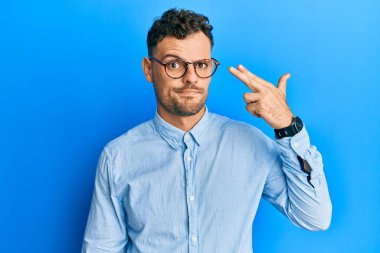 Gündelik giysiler giymiş, gözlüklü genç bir İspanyol adam kendini vuruyor ve öldürüyor. Silah gibi el ve parmakları işaret ediyor. İntihar hareketi.. 