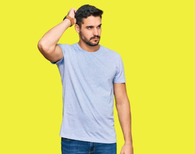 Gündelik kıyafetler giyen genç İspanyol adam soru sorup kafasını karıştırıyor. Şüpheyle kararsız, kafa kafaya düşünerek. Düşünceli kavram. 