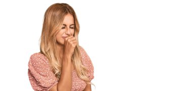 Yazlık bluz giyen güzel sarışın kadın kendini iyi hissetmiyor ve soğuk algınlığı veya bronşitin belirtisi olarak öksürüyor. sağlık hizmeti kavramı. 