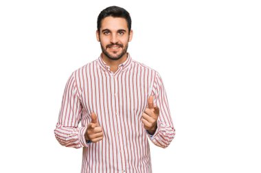 İş gömleği giyen genç İspanyol adam mutlu ve komik yüzüyle kamerayı işaret ediyor. iyi enerji ve titreşimler. 