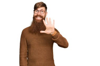 Genç İrlandalı kızıl elbiseli ve gözlüklü adam beş numarayı gösterip işaret ederken kendinden emin ve mutlu bir şekilde gülümsüyor.. 