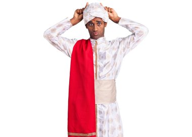 Gelenek giyinmiş Afrikalı yakışıklı bir adam Sherwani sari elbisesi giyiyor ve parmağıyla boynuz gibi komik hareketler yapıyor. 