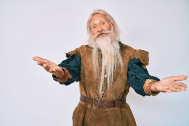 Gri saçlı, uzun sakallı, Viking kostümü giyen, gülümseyen ve yardım eli uzatan yaşlı bir adam.. 