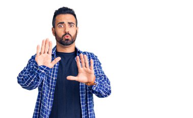 Latin asıllı genç bir adam, sıradan kıyafetler giyip avuçlarını hareket ettiriyor. Korkmuş ve iğrenç bir ifadeyle reddediyor. Dur ve yasakla. 