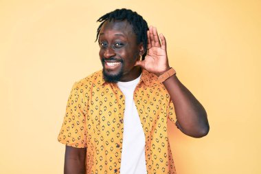 Saçları günlük kıyafetlerle gezen, ağzı kulaklarına varan gülümseyerek dedikodu ve dedikoduları dinleyen Afro-Amerikalı genç bir adam. Sağırlık kavramı. 