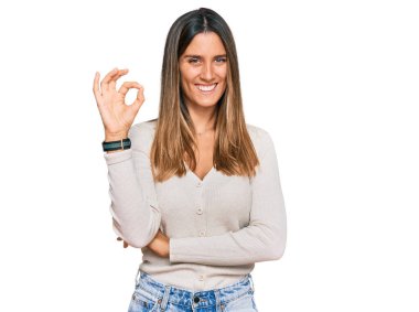 Gündelik kıyafetler giyen, gülümseyen genç bir kadın el ve parmaklarıyla 