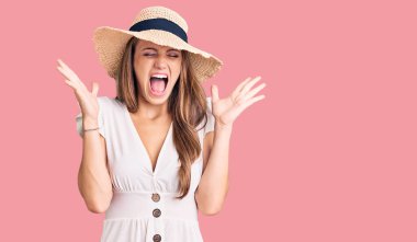 Yazlık elbise giyen, şapkalı genç ve güzel bir kadın başarının çılgınlığını kutluyor. Kollarını kaldırmış, gözlerini kapatmış heyecanlı çığlıklar atıyor. Kazanan konsept 