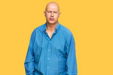 Orta yaşlı kel bir adam, günlük kıyafetlerini giymiş kameraya bakıyor ve güzel ve seksi bir şekilde yayına öpücük yolluyor. aşk ifadesi. 