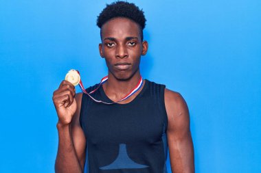 Genç Afro-Amerikan erkek spor giysisi giyiyor. Madalya takıyor. Düşünme tavrı takınıyor. 