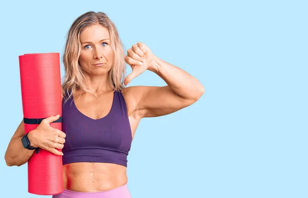 Donna Bionda Mezza Età Possesso Tappetino Yoga Con Faccia Arrabbiata — Foto Stock