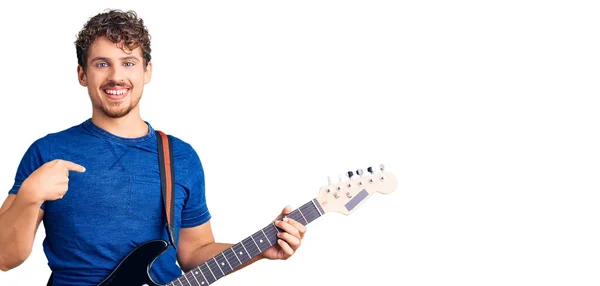 Jovem Homem Bonito Com Cabelo Encaracolado Tocando Guitarra Elétrica Apontando — Fotografia de Stock