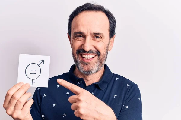 Middle age man asking for sex discrimination holding paper with gender equality message smiling happy pointing with hand and finger