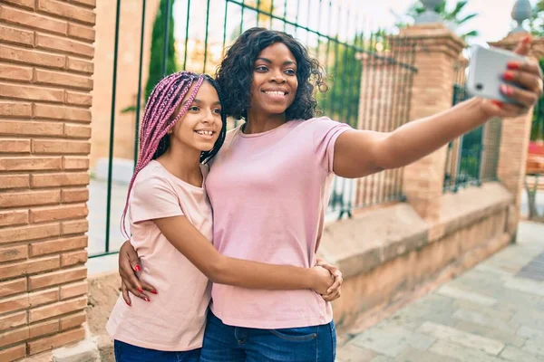 アフリカ系アメリカ人の母親と娘は 市内のスマートフォンで自画自賛しています — ストック写真
