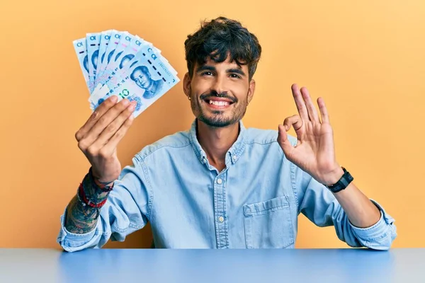Fiatal Spanyol Férfi Kezében Jüan Kínai Bankjegyek Asztalon Csinál Rendben — Stock Fotó