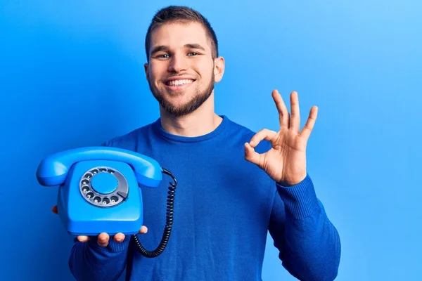 Junger Gutaussehender Mann Der Ein Altes Telefon Der Hand Hält — Stockfoto