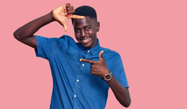 若いアフリカ系アメリカ人の男性が幸せな顔で手や指でフレームを作る笑顔カジュアルな服を着て 創造性と写真の概念 — ストック写真
