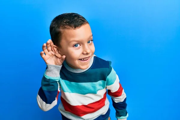 Menino Usando Camisola Listrada Sorrindo Com Mão Sobre Orelha Ouvindo — Fotografia de Stock