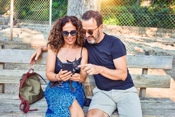 Middelbare Leeftijd Paar Glimlachend Gelukkig Met Behulp Van Smartphone Zittend — Stockfoto