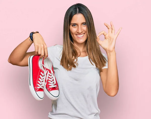Mujer Joven Sosteniendo Zapatos Casuales Rojos Haciendo Signo Con Los —  Fotos de Stock
