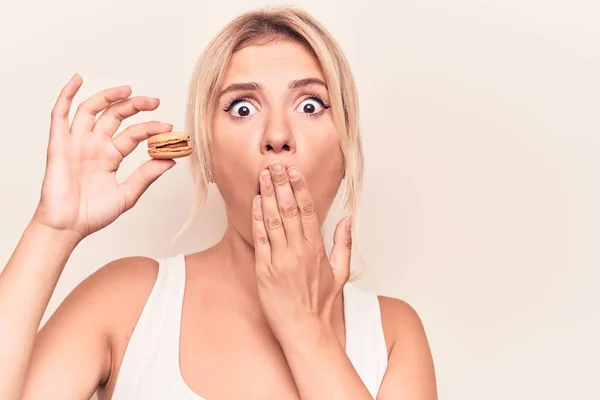 Jovem Loira Comendo Sobremesa Francesa Segurando Macaron Chocolate Sobre Fundo — Fotografia de Stock