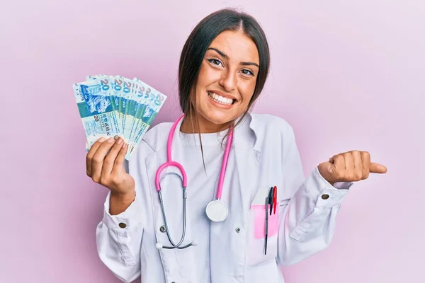 Mulher Hispânica Bonita Vestindo Uniforme Médico Segurando Dólares Hong Kong — Fotografia de Stock