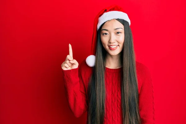 Jovem Chinesa Usando Chapéu Natal Sorrindo Com Uma Ideia Pergunta — Fotografia de Stock