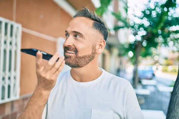 Medelålders Stilig Man Ler Glad Skicka Röstmeddelande Med Smartphone Staden — Stockfoto