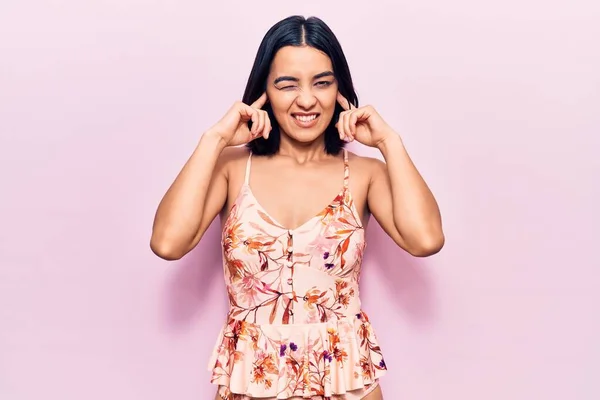 大きな音楽のノイズのためにいらいらする表情で指で耳を覆うカジュアルな服を着て若い美しいラテン語の女性 聴覚障害の概念 — ストック写真