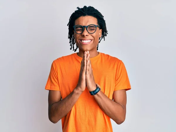 Jovem Afro Americano Vestindo Roupas Casuais Óculos Orando Com Mãos — Fotografia de Stock