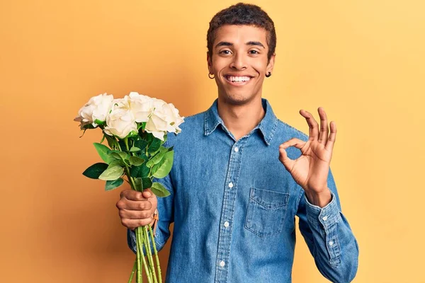 年轻的非洲裔美国人 手握鲜花 手握手签 微笑着表示友善的姿态 象征着优秀的象征 — 图库照片