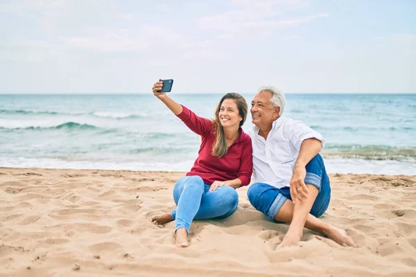 Orta Yaşlı Spanyol Çift Kumsalda Telefon Başında Mutlu Bir Şekilde — Stok fotoğraf