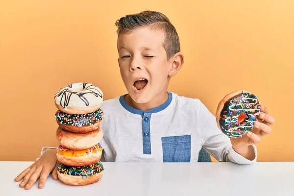 Adorable Niño Caucásico Comiendo Donas Para Desayuno Guiño Mirando Cámara — Foto de Stock