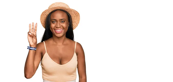 年轻的黑人妇女戴着夏帽 手指点点 脸上挂着自信和快乐的笑容 — 图库照片