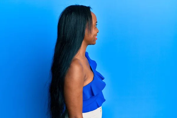 Mavi Arka Plan Üzerine Günlük Giysiler Giyen Genç Afrikalı Kadın — Stok fotoğraf