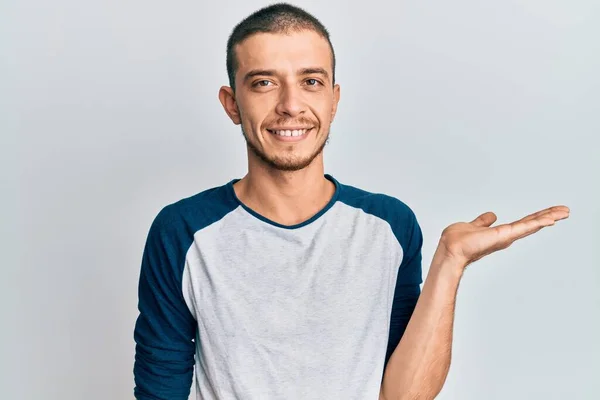 Spaanse Jongeman Casual Kleding Lachend Vrolijk Presenteren Wijzen Met Handpalm — Stockfoto