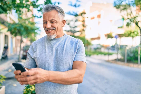 Medelåldern Latinamerikansk Gråhårig Man Ler Glad Med Smartphone Stan — Stockfoto