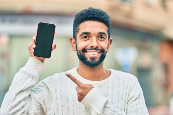 Jovem Afro Americano Sorrindo Feliz Mostrando Smartphone Tela Cidade — Fotografia de Stock